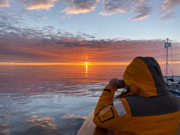 A breathtaking view of a vibrant sunset over the Antarctic sea during a polar expedition.